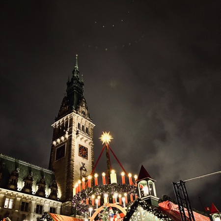 Das Rathaus anm Abend, man sieht Teile der beleuchteten Weihnachtsmarkt-Deko davor