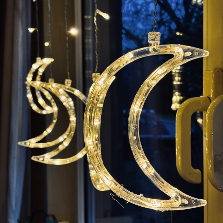Weihnachtsdeko an einem Fenster, leuchtende Halbmonde