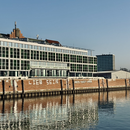 Blick von der Oberhafenbrücke auf ein Graffiti ander Kaimauer: "Lieb sein"