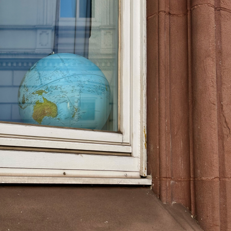Ein Globus auf einer Fensterbank, von außen fotografiert