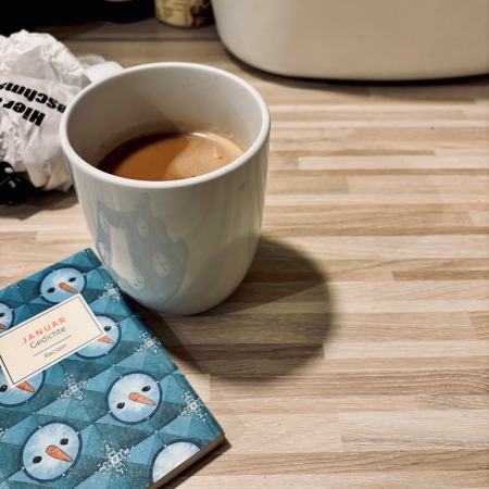Ein Becher Kaffe und ein schmaler Band mit Januar-Gedichten