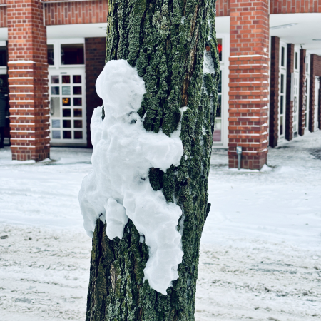 Ein Schneemann, der an einem Baun hochklettert