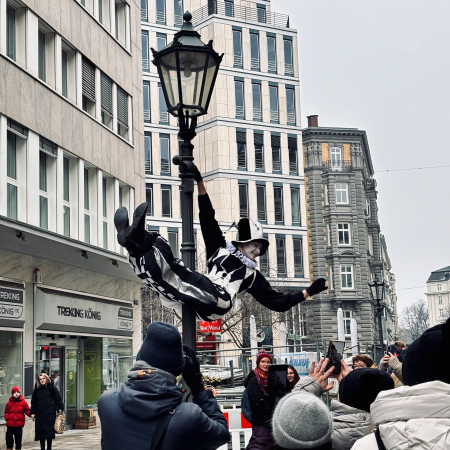 Ein Pierrot im venezianischen Karneval, turnend an einem Laternenmast