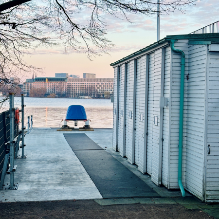Bootsschuppen und ein Tretboot auf einem Steg an der Außenalster