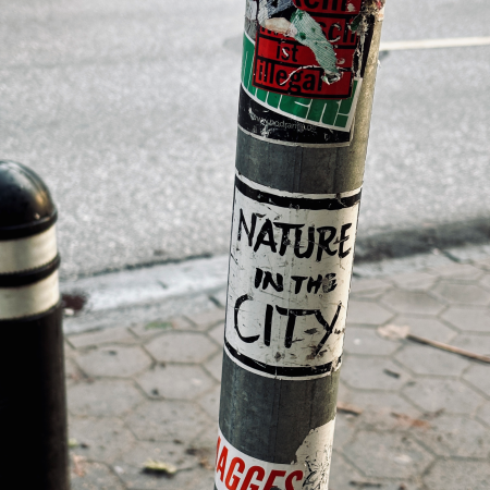 Ein Aufkleber an einem Verkehrsschildmast: Nature in the city
