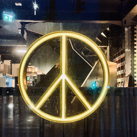 Das Peace-Zeichen in Neon in einem Schaufenster