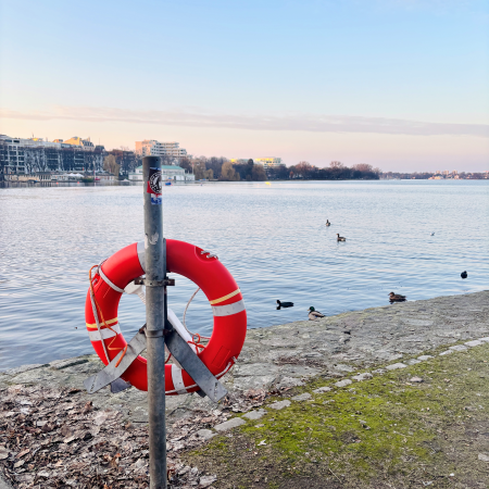 Blick über die Außenalster, ein Rettungsring in der Halterung im Vordergrund