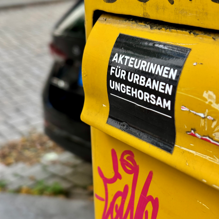 Ein Sticker an einem Briefkasten: "Akteurinnen für urbanen Ungehorsam"