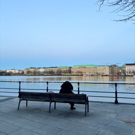 Ein Mensch auf einer Bank an der Außenalster