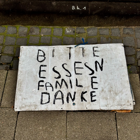 Das Pappschild eines bettelnden Menschen "Bitte Essen"