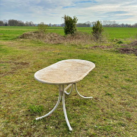 Ein angegammelter Gartrentisch vor freiem Feld