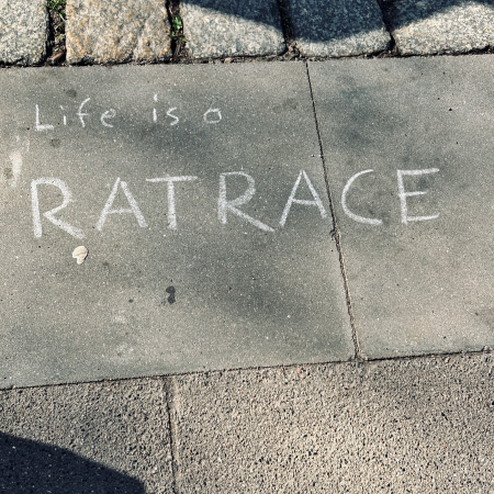 Kreideschrift auf dem Pflaster. Life is a ratrace