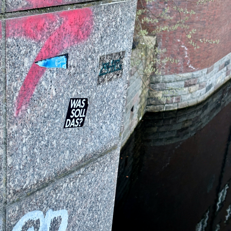 Ein Aufkleber an einer Brücke: Was soll das