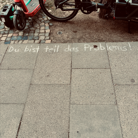 Kreideschrift auf dem Pflaster: Du bist Teil des Problems (Teil fälschlicherweise kleingeschrieben)