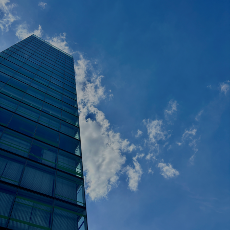 Blauen Himmel spiegelnde gläserne Hochhausfassaden