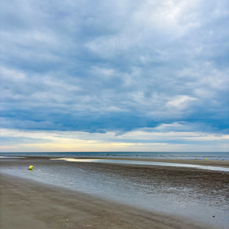 Strand in SPO, abendblauer Himmel, wolkenverhangen. eine Boje liegt auf dem Sand