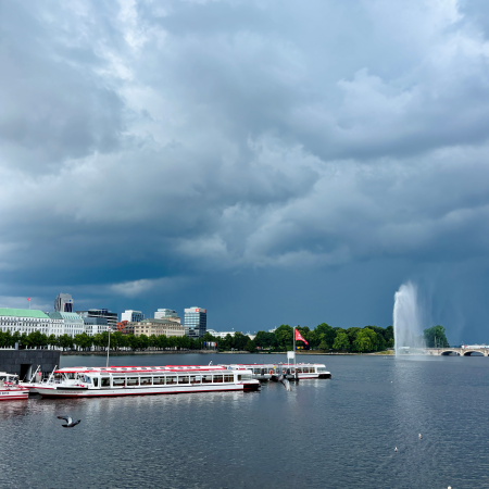 Blick über die Binnenalster mit Fontäne und Alsterbooten vom Jungfernstieg aus