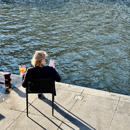 Außengastro an der Kleinen Alster, eine Frau mit Aperol, von oben und von hinten fotografiert