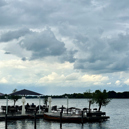 Außengastro auf einem Steg an der Auißenalster, unter wolkenverhangenem Himmel