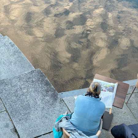 Eine Zeitung lesende Frau an der Kleinen Alster