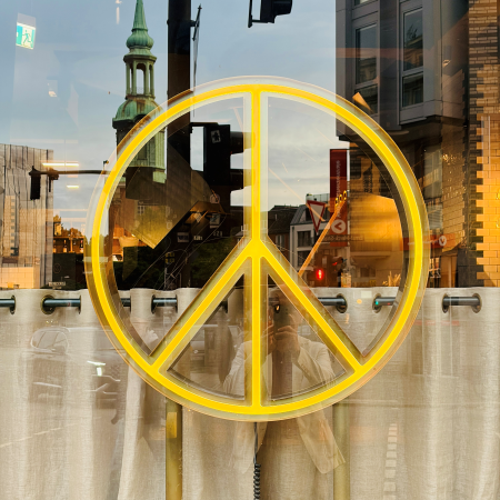 Ein leuchtendes Peace-Zeichen in einem Schaufenster