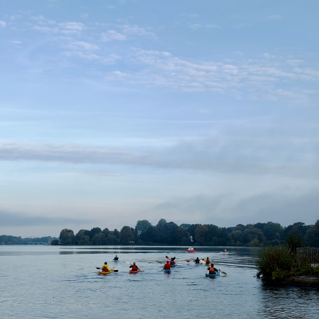 Eine Gruppe Ruderer in Kajaks (?) auf der Außenalster