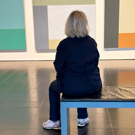 Eine Frau sitzt betrachtend vor Novros-Werken