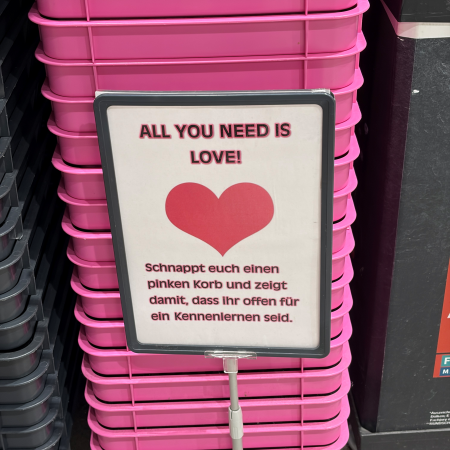 Ein Stapel pinkfarbener Einkaufskörbe bei Edeka