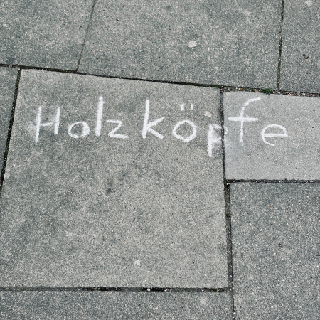 Kreide auf Pflaster: Holzköpfe