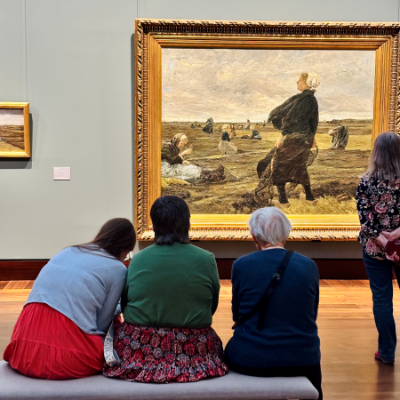 Gäste in der Kunsthalle, von einer Bank aus ein Gemälde betrachtend