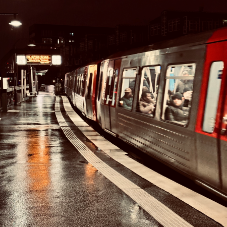 Eine U-Bahn bei Nacht und Regen an einer Station